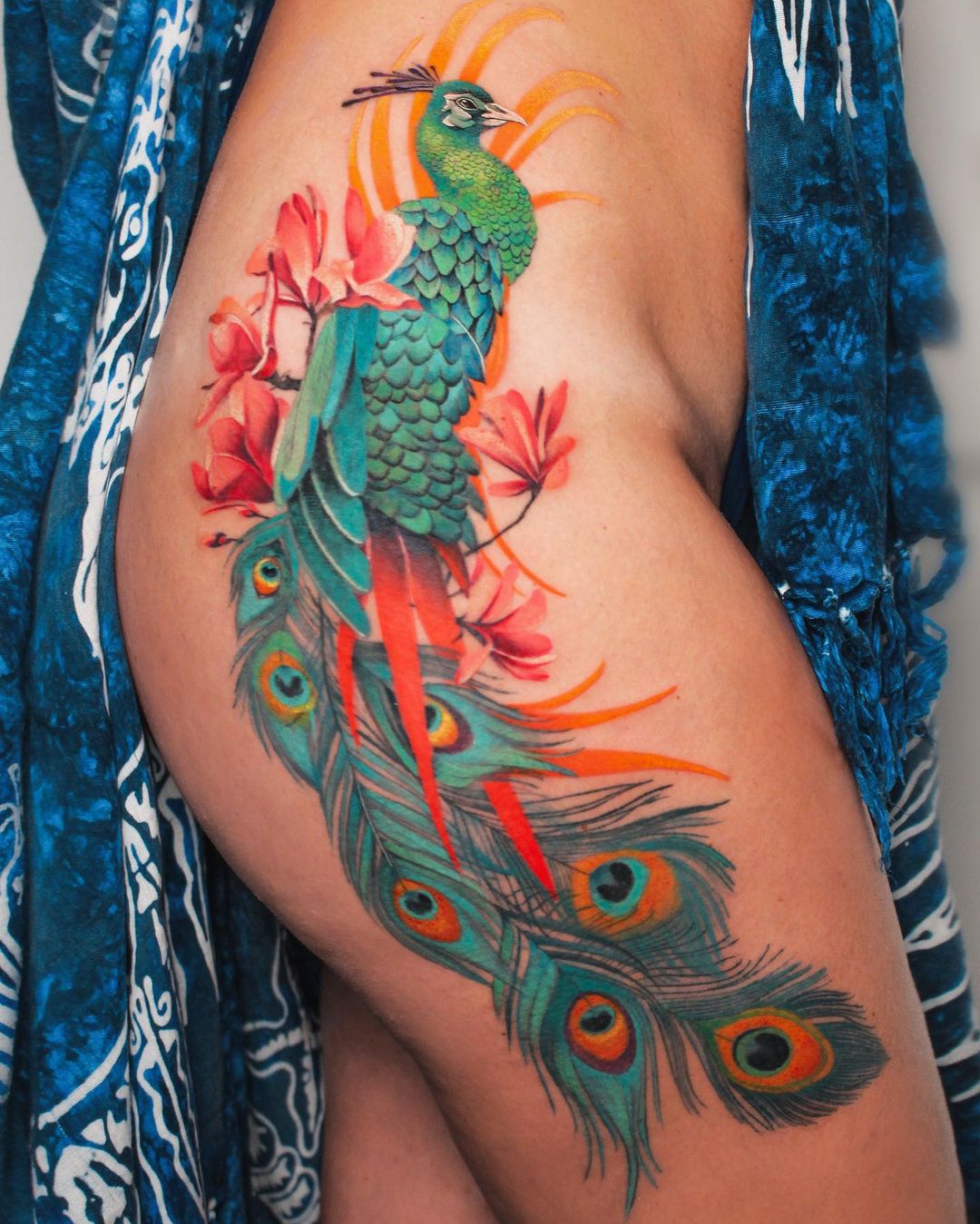 Tatuagem Pavão colorido na coxa. Tatuagem feminina. 